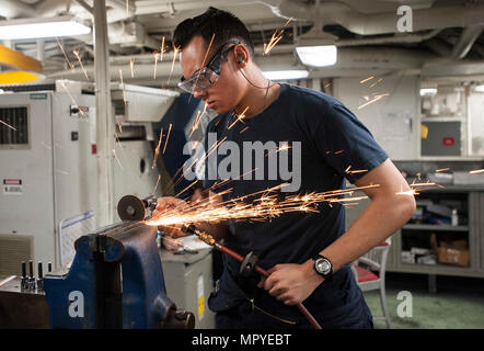 170423-N-RZ514-028 GOLFO ARABICO (23 aprile 2017) Macchine aggiustatore di terza classe Cody Kratz macina in metallo il negozio di macchina a bordo della portaerei USS George H.W. Bussola (CVN 77) (GHWB). GHWB è distribuito negli Stati Uniti Quinta Flotta area di operazioni a sostegno della sicurezza marittima operazioni destinate a rassicurare gli alleati e partner e preservare la libertà di navigazione e il libero flusso di commercio nella regione. (U.S. Foto di Marina di Massa Specialista comunicazione marinaio Jennifer M. Kirkman/rilasciato) Foto Stock