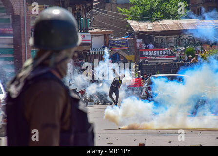 Un protestor Kashmir getta indietro un esploso di una lacerazione della shell di fumo verso la polizia durante scontri nella città vecchia di Srinagar capitale estiva del Kashmir indiano dopo la preghiera del venerdì. Scontri scoppiati subito dopo la preghiera del venerdì in area del centro cittadino di Srinagar, Kashmir indiano, il venerdì. Diverse persone sono rimaste ferite dopo che le forze governative hanno sparato pistole di pellet e gas lacrimogeni gusci su persone che si sono riuniti dopo venerdì pomeriggio le preghiere che protestavano contro la regola di indiana nella regione contesa. Foto Stock