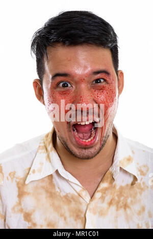 Volto del giovane pazzo uomo asiatico urlando con il sangue sulla faccia Foto Stock