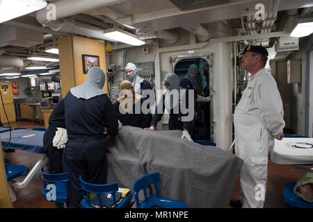 170427-N-ZE250-057 OCEANO ATLANTICO (27 aprile 2017) Royal Navy chief petty officer Chaz Charlesworth, destra, osserva velisti assegnati al Arleigh Burke-class guidato-missile destroyer USS Carney (DDG 64) fornendo assistenza medica alle vittime simulato durante un quartieri generali trapano. Carney è distribuita a Rota, Spagna, conducendo la sua pattuglia di terzi negli Stati Uniti Sesta flotta area di operazioni a sostegno degli Stati Uniti per gli interessi di sicurezza nazionali in Europa. (U.S. Foto di Marina di Massa lo specialista di comunicazione di terza classe Weston Jones/rilasciato) Foto Stock