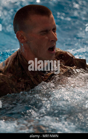 Spc. William Lloyd, un cavo Installer-Maintainer sistemi con la 316supporto comando (Expeditionary), de-vesti dopo aver completato la parte di nuoto delle forze armate tedesche il badge di qualificazione. Forze armate tedesche distintivo per competenza militare è uno dei più ricercati dopo premi stranieri nell'esercito degli Stati Uniti. La 316CES e il primo supporto di comando (Teatro) aveva i privilegi di ospitare il riconoscimento delle qualifiche a Camp Arifjan in Kuwait il 27 aprile 2017. Foto Stock