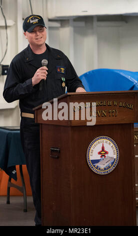 170501-N-FE442-050 GOLFO ARABICO (1 maggio 2017) alfiere Christopher Helms parla durante la sua cerimonia di messa in servizio a bordo della portaerei USS George H.W. Bussola (CVN 77) (GHWB). GHWB è distribuito negli Stati Uniti Quinta Flotta area di operazioni a sostegno della sicurezza marittima operazioni destinate a rassicurare gli alleati e partner e preservare la libertà di navigazione e il libero flusso di commercio nella regione. (U.S. Foto di Marina di Massa lo specialista di comunicazione di terza classe Matlage Matt/rilasciato) Foto Stock