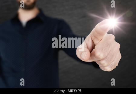 Uomo in camicia blu toccando interfaccia traslucido con un dito di una mano modello Foto Stock