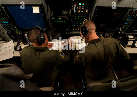 Stati Uniti Air Force Il Mag. Izzy Remo, sinistra, un conduttore di prova-airborne, E DEGLI STATI UNITI Air Force Capt. Greg Carter, a destra di un vice-missile equipaggio combat commander-airborne, sia dai conti nella 625 a operazioni strategiche Squadron, andare oltre il lancio di missili durante le procedure di volo gloria 220 sopra l'Oceano Pacifico, 26 aprile 2017. Gloria Viaggio è operativo un test di lancio che continua una lunga storia di Gamma Western lancia utilizzata per verificare e convalidare e migliorare la capacità della nazione di forza di missili a gittata intercontinentale. (Foto a cura di sicurezza) (U.S. Air Force foto di Airman 1. Classe Keifer Bowes) Foto Stock