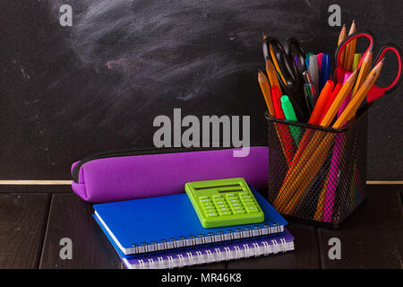 Matite multicolore con lavagna nera come sfondo. Si torna a scuola concept Foto Stock