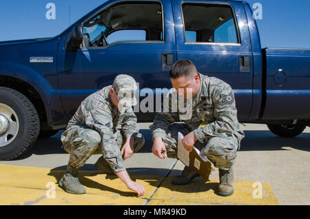 SrA Mike Vasilakos Engineering Assistant, 108th ingegnere civile squadrone e Tech. Sgt. Sean Giuseppe, Operations Manager, 108th ingegnere civile Squadron, controllare e documentare una crepa nel cemento della 108th parcheggio aeromobili rampa che senza una corretta manutenzione ha il potenziale di creare FOD (oggetto estraneo detriti) e i danni di un aeromobile. (U.S. Air National Guard photo by Staff Sgt. Ross A. Whitley/rilasciato) Foto Stock