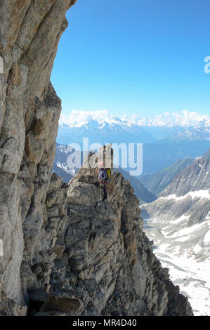 Maschio guida di montagna portano la scalata su esposta una cresta di granito nelle Alpi Foto Stock