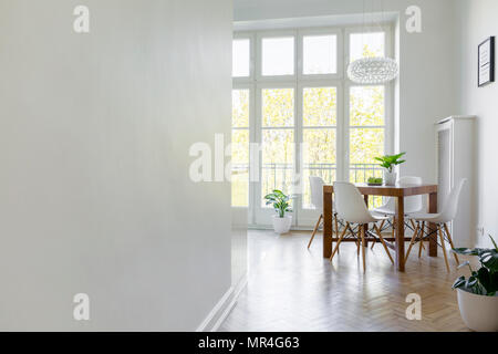 Copia dello spazio sul muro bianco nella luminosa sala da pranzo interno con sedie al tavolo accanto alla finestra. Foto reale Foto Stock