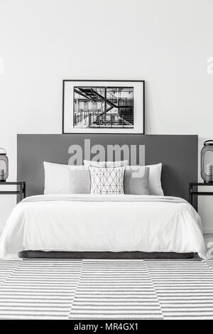 Poster sulla testata del letto bianco in minima hotel interiore camera da letto con moquette a motivi geometrici Foto Stock