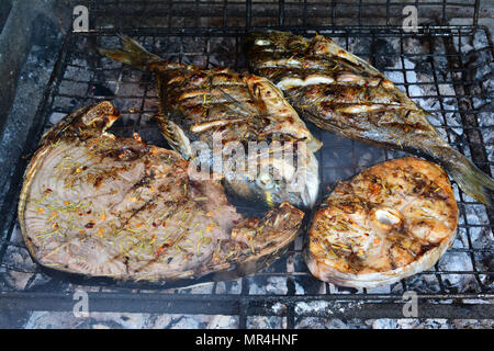 Il tonno e il pesce spada bistecche e due orate con spezie sul grill, quasi fatta, vista laterale Foto Stock