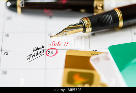 Promemoria Venerdì nero vendita in bianco calendario con la penna nera e carte di credito. Foto Stock
