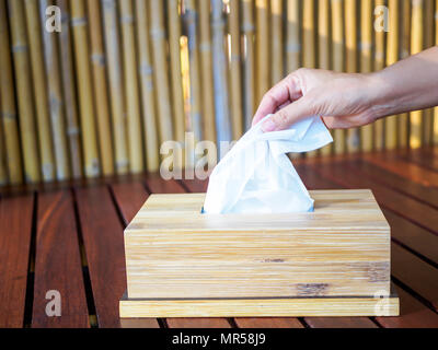 Donna raccolta a mano un tessuto bianco dalla casella di tessuto. Foto Stock