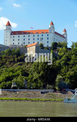 Fotografia di presa degli edifici lungo il corso del fiume Danubio a Bratislava, la capitale della Slovacchia. Il rosso coperto e il castello di Bratislava è visibile. Il castello risale al XIII secolo e ospita il parlamento slovacco. Xxi secolo Foto Stock