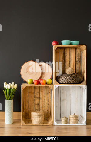 Regale ecologico realizzato da scatole di legno su uno sfondo scuro Foto Stock