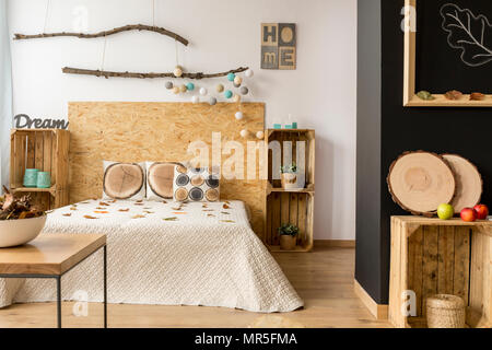 Ispirando accogliente camera da letto interni decorati con accessori in legno Foto Stock