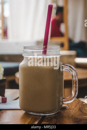 Rinfrescante caffè ghiacciato sul tavolo di un caffè in un barattolo di mason Foto Stock