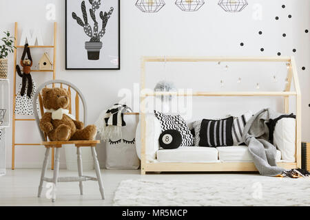 Bianco e nero boy camera da letto con letto di casa e sedia Foto Stock