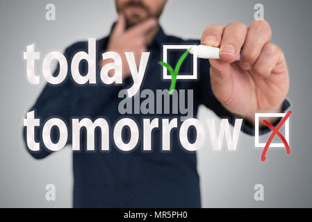 Uomo con penna scegliendo tra oggi e domani contro la procrastinazione concept Foto Stock