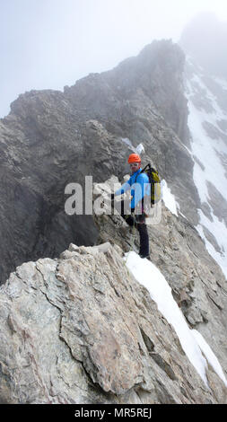 Maschio guida di montagna portano la scalata su esposta una cresta di granito nelle Alpi Foto Stock