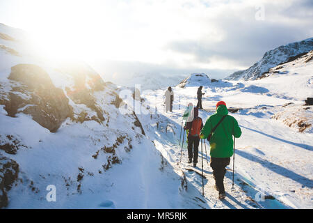 Processo di escursionismo nel nord della Norvegia, Isole Lofoten, Nordland, sulla strada di montagna Ryten e Kvalvika beach, con un gruppi di escursionisti e mountai Foto Stock