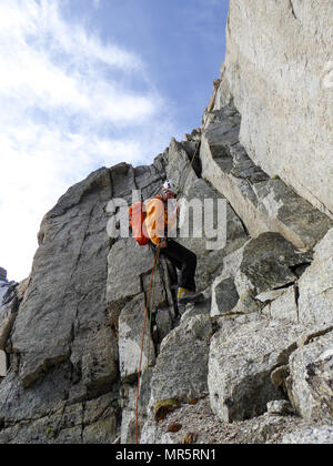 Maschio di rocciatore la discesa in corda doppia off una ripida roccia arrampicata nelle Alpi francesi Foto Stock