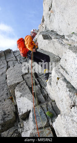 Maschio di rocciatore la discesa in corda doppia off una ripida roccia arrampicata nelle Alpi francesi Foto Stock