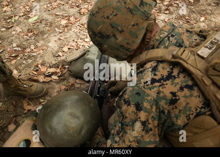 Sgt. Timothy Kuklis, un assaultman con scopi speciali Air-Ground Marine Task Force - Risposta in caso di crisi - Africa, cancella un'ostruzione in un M16A2 fucile di servizio per un membro del Senegal di Compagnie Fusilier de Marin Commando durante un live-Incendio campo a Toubakouta, Senegal, 13 aprile 2017. Marines con SPMAGTF-CR-AF e il COFUMACO condotta a quattro alla settimana di formazione professionale esercizio che includeva il combattimento avanzate tecniche di cottura, una mitragliatrice gamma e un live-fire attacco di plotone di gamma. (U.S. Marine Corps foto di Sgt. Samuel Guerra/rilasciato) Foto Stock