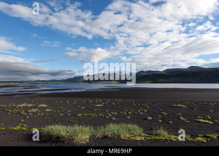 Paesaggio vulcanico con lava nera spiaggia, montagne e nuvole, Öxarfjördur Bay, a nord dell'Islanda, Islanda Foto Stock