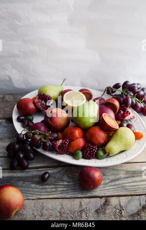 Buon piatto di frutta fresca con melograno, uva e pere Foto Stock