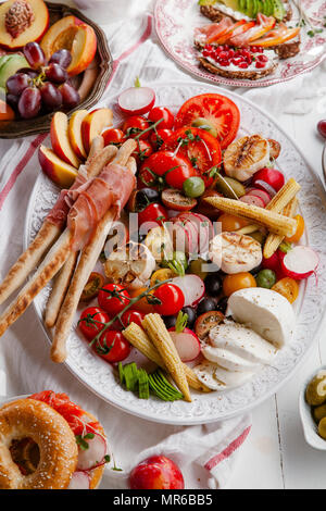 Varietà di spuntini preparati per picnic vino summer party con frutta fresca, verdura, prosciutto e chesse Foto Stock