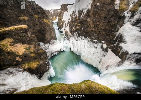 Parzialmente cascate ghiacciate in un canyon, Kolugljúfur gorge, regione nord-occidentale, Islanda Foto Stock