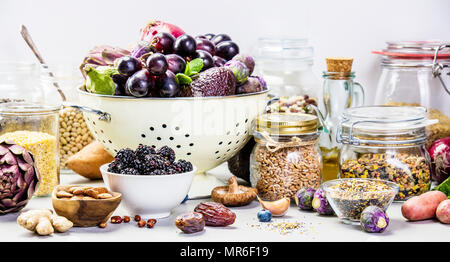 Dieta bilanciata, cucina vegetariana, raw e pulire il concetto di mangiare - close up organico fresco frutta e verdura, cereali, legumi e i dadi sulla concre Foto Stock