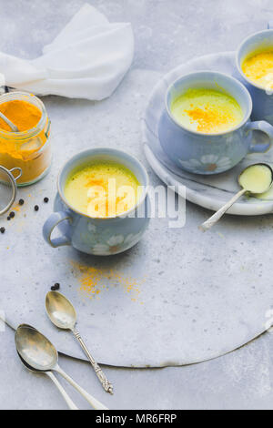 Golden Curcuma latte servite in tazze blu Foto Stock