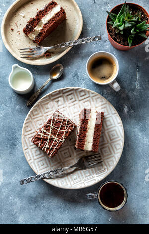 Torta al cioccolato farciti di crema sulla piastra e il caffè sul tavolo Foto Stock