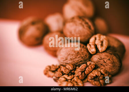 Noci e nocciole su sfondo beige Foto Stock