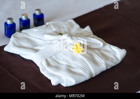 Close-up shot di prodotti da bagno di lusso con accappatoio sul letto in camera di albergo Foto Stock