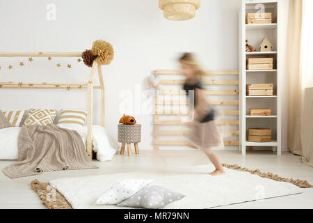 Ragazza che corre in uno stile scandinavo camera da letto Foto Stock