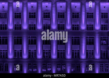 Architettura di sfondo nei toni del moderno Ferro-parete in cemento con finestre. Edifici multipiano di notte illuminata di windows. Moderna città al neon, arte immagine di tessitura Foto Stock