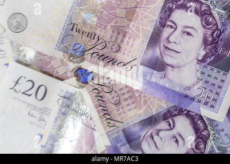 Sullo sfondo di un gran mucchio di venti UK sterling pound banconote Foto Stock