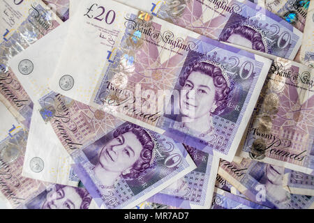 Sullo sfondo di un gran mucchio di venti UK sterling pound banconote Foto Stock