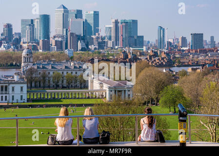 LONDON, Regno Unito - 20 aprile: Gente seduta in cima alla collina di Greenwich Park visualizzazione della skyline di Londra il 20 aprile 2018 a Londra Foto Stock