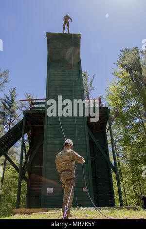 Il personale Sgt. Tyler Beck belays un soldato da reclutare Supporto Programma (RSP) giù un piede 55 a parete Bog Brook Area Formazione in Gàlaad, Maine. I soldati del RSP sono nuovi per la Guardia Nazionale e alla formazione al fine di diventare più pronto a partecipare a base di addestramento al combattimento o avanzati di formazione individuali il 20 maggio 2017. Foto Stock