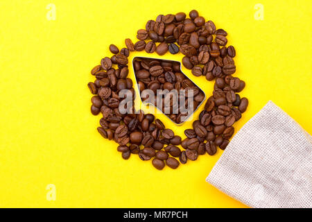 I chicchi di caffè in forma di freccia su sfondo giallo Foto Stock