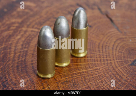 Il calibro 9mm cartuccia su sfondo di legno Foto Stock