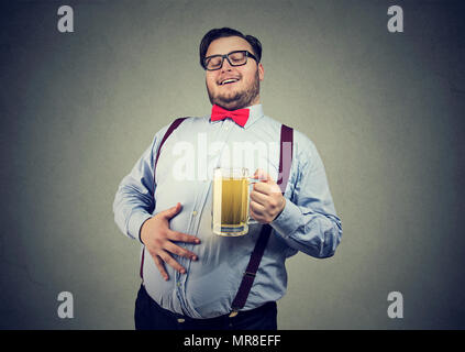 Giovani sovrappeso uomo felice con ventre gonfio di bere birra godendo la sua bevanda Foto Stock