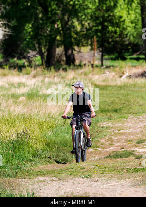 Giovane uomo mountain bike su una centrale di Colorado ranch; Salida; Colorado; USA Foto Stock