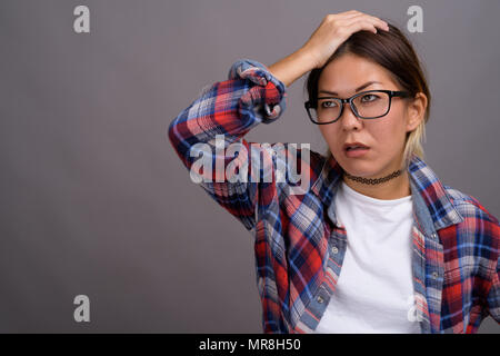 Giovane bella donna kazaka contro uno sfondo grigio Foto Stock