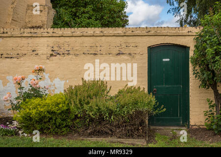 Porta verde e parete gialla intemperie a Richmond Tasmania Australia Foto Stock