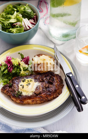 Bistecca con patate al forno e insalata mista Foto Stock