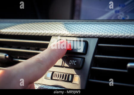 Premendo il pulsante di avvertimento sulla moderna plancia auto Foto Stock